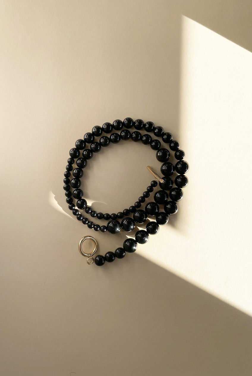 Nyx black onyx necklace on a warm light background